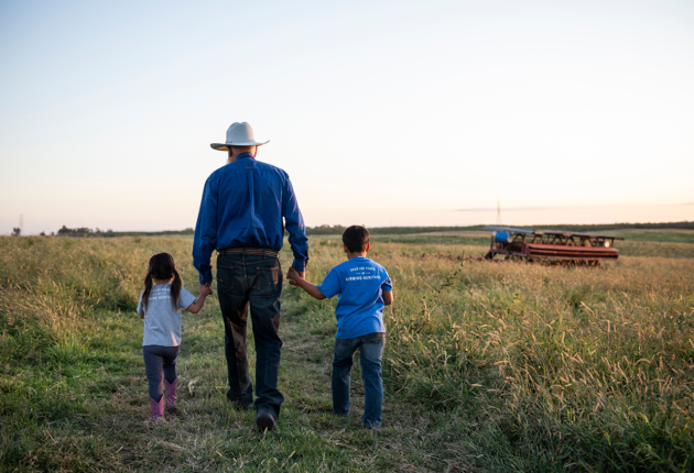 Farmer with children walking in a field