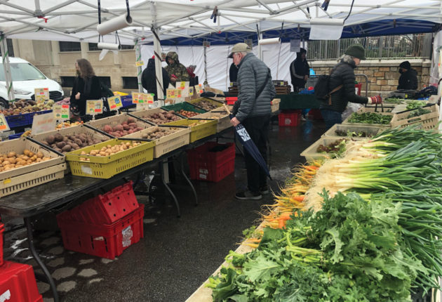 Farmer's market stand with tables of fruit and vegetables